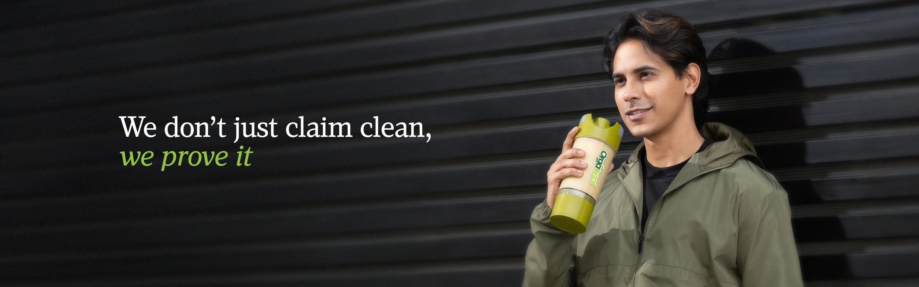 Man holding a green bottle with text 'We don't just claim clean, we prove it' on a dark background